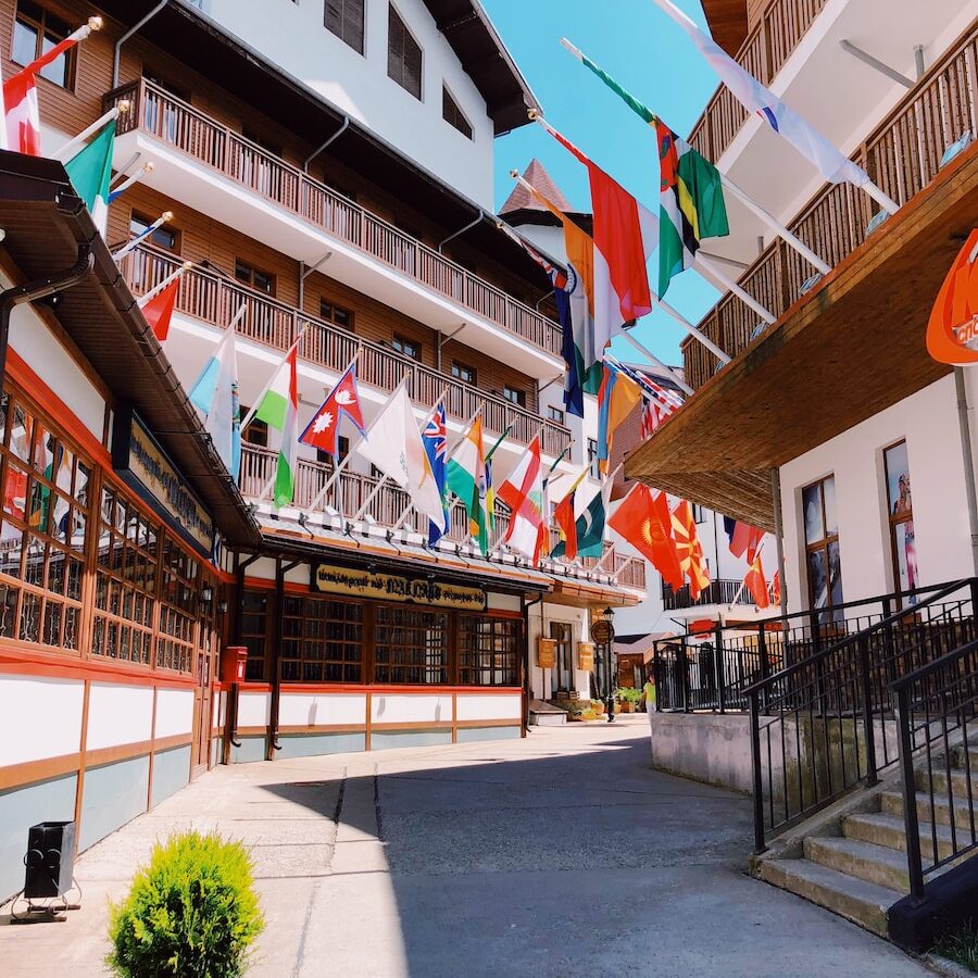 assorted flags on brown and white buildings during daytime