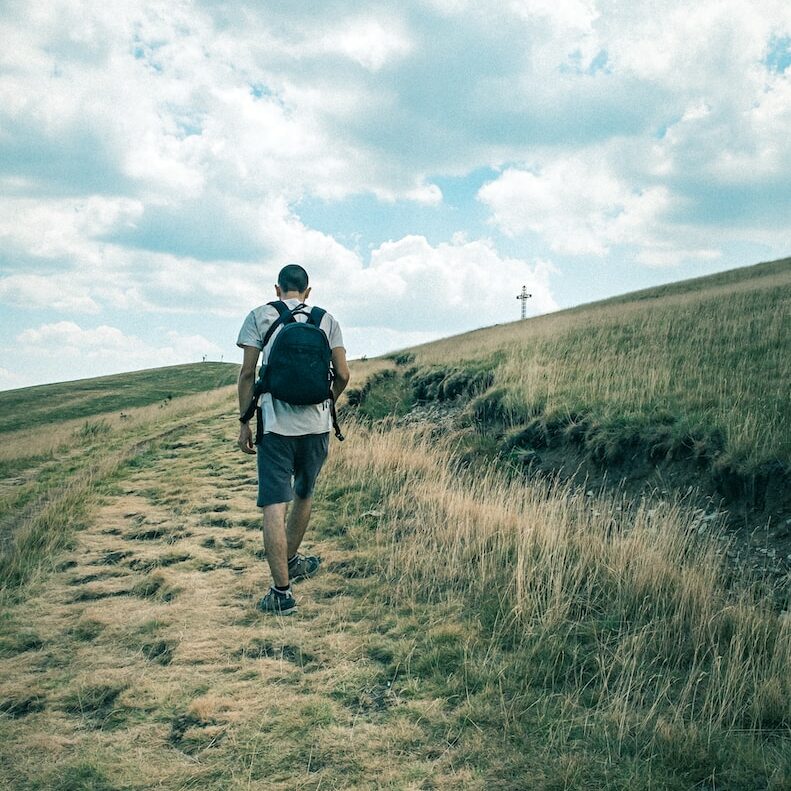Photo by Daniele Franchi man in black jacket walking on brown field during daytime